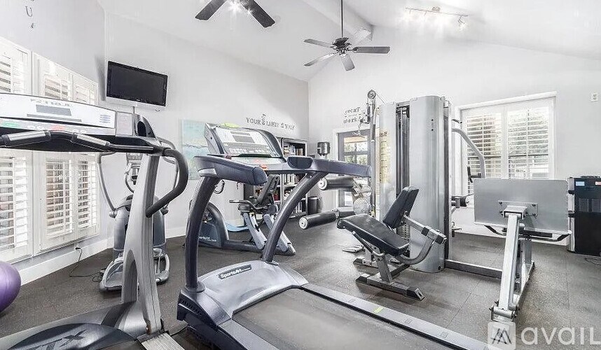 A gym with treadmills, weights, and exercise equipment.