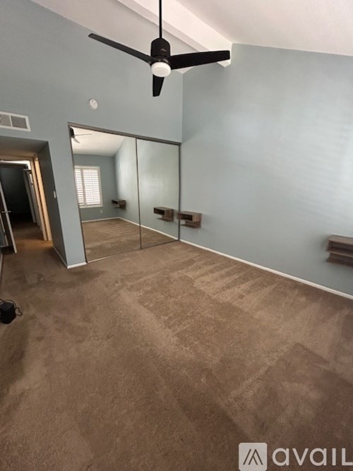 A room with a ceiling fan and a carpeted floor.