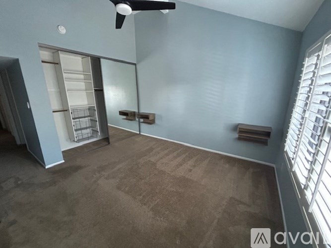 A room with a ceiling fan and a large mirror.