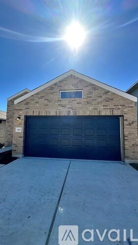 A house with a large garage door and a sunny sky above.