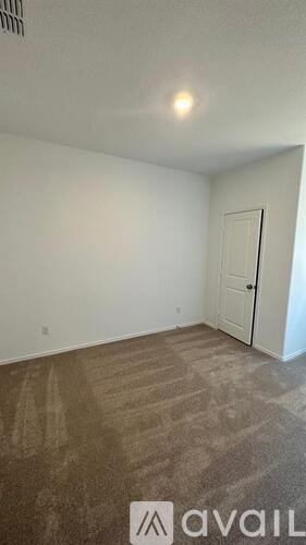 A room with a carpeted floor and a door.