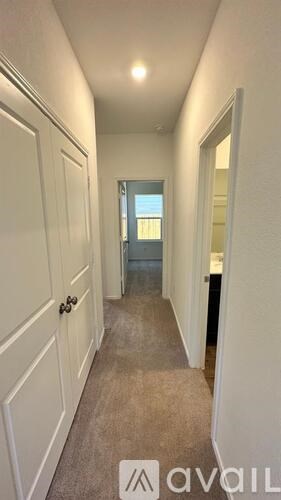 A hallway with white walls and a carpeted floor.