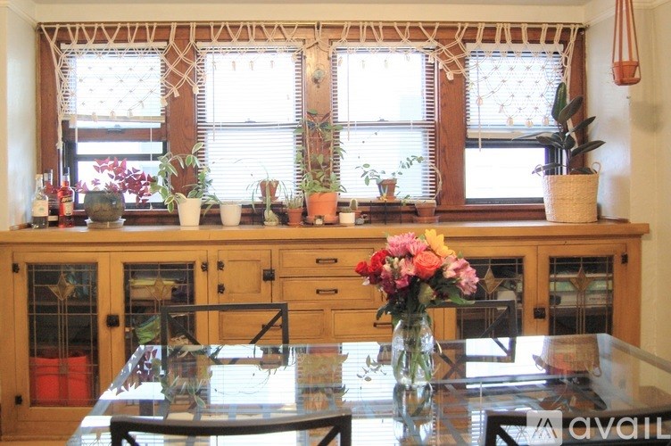 A kitchen with a table and chairs in front of a window with blinds.