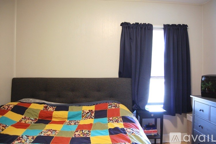 A bed with a quilt on it in a bedroom.