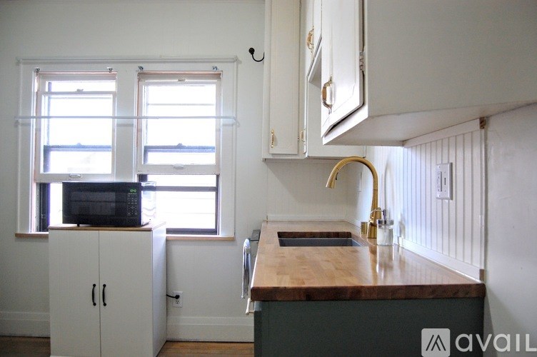 A kitchen with a wooden counter top and white cabinets.