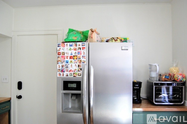 A refrigerator covered in magnets and papers is in a kitchen.