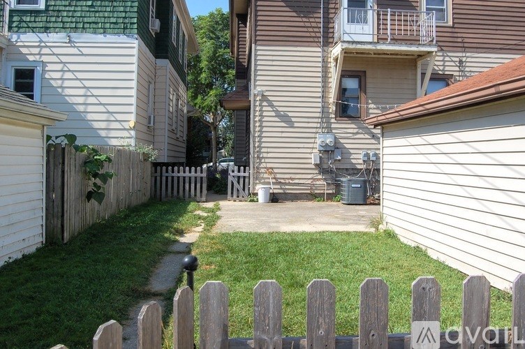 A backyard with a wooden fence and a green lawn.
