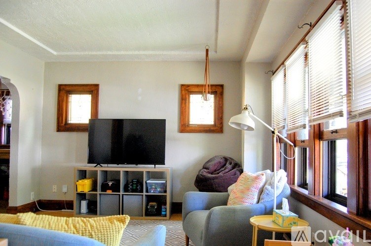 A living room with a television and a grey couch.