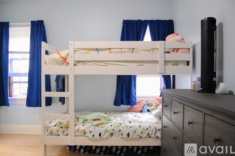 A white bunk bed with a single bed underneath it.