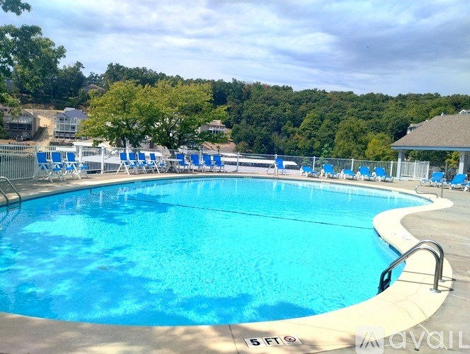 A large outdoor swimming pool with blue water and lounge chairs.