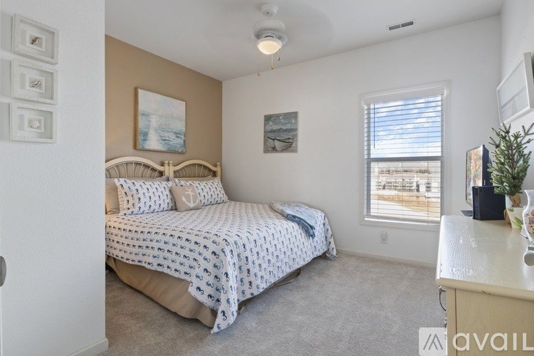 A bedroom with a bed, a window, and a painting on the wall.