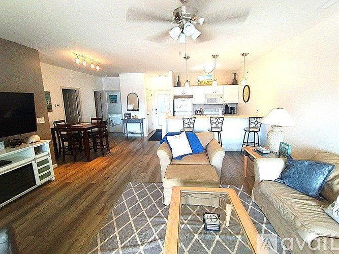 A living room with a couch, a coffee table, and a television.