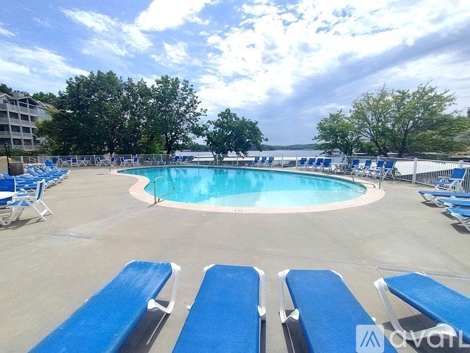 A pool surrounded by blue lounge chairs.