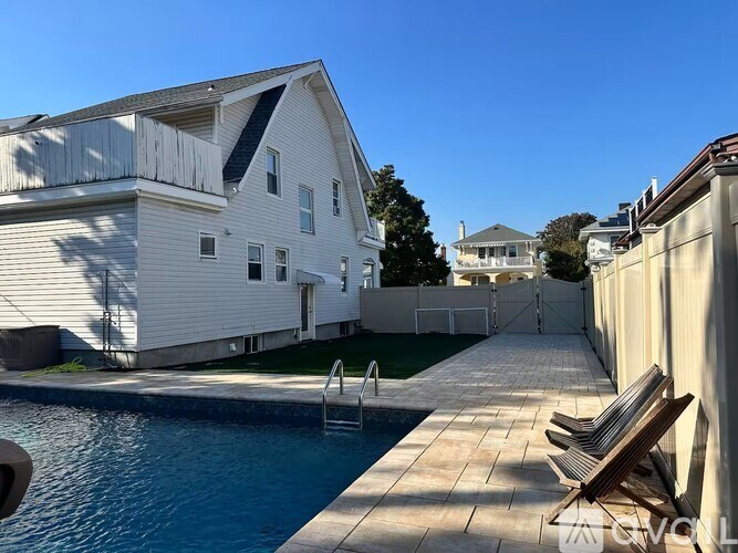 A white house with a pool in the backyard.
