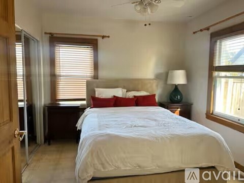 A bedroom with a large bed and a ceiling fan.