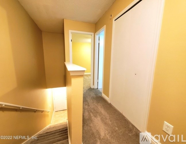 A hallway with a white door and a window with a white frame.