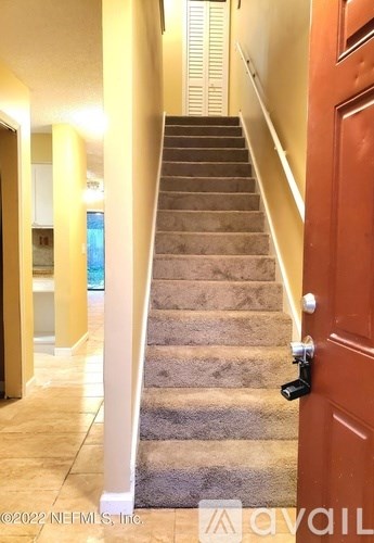 A staircase with a brown door on the right side.