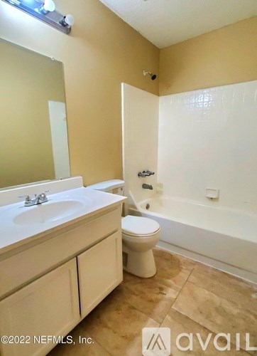 A bathroom with a toilet, sink, and bathtub.