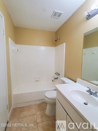 A bathroom with a toilet, sink, and bathtub.