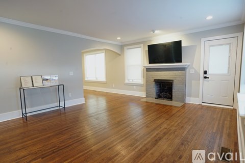 A living room with a fireplace and a television on the wall.