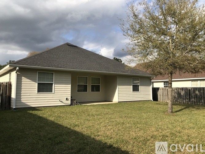 A house with a grey roof and a tree in front.