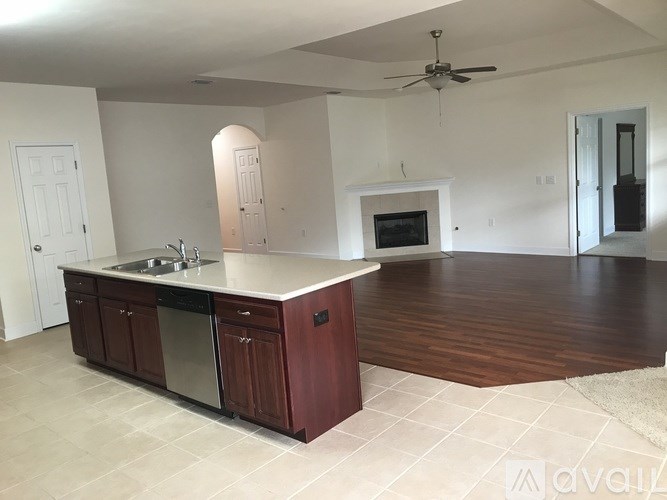 A kitchen with a sink, stove, and cabinets.