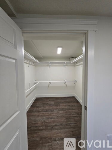 A hallway with a wooden floor and white walls.