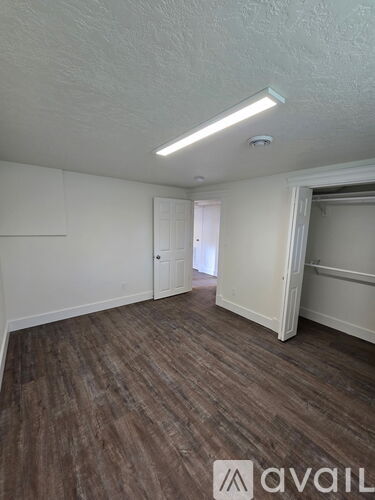 A room with wooden flooring and white walls.