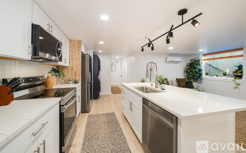 A modern kitchen with white cabinets and stainless steel appliances.