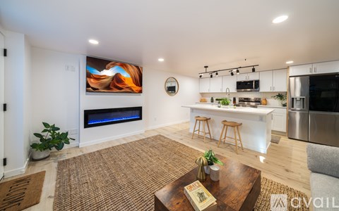A modern living room with a fireplace and a painting on the wall.