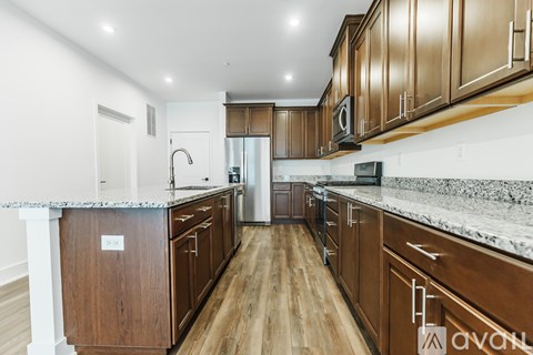 A kitchen with wooden cabinets and a marble countertop.
