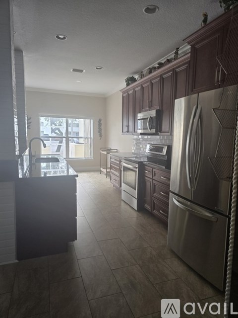 A kitchen with dark wood cabinets and stainless steel appliances.