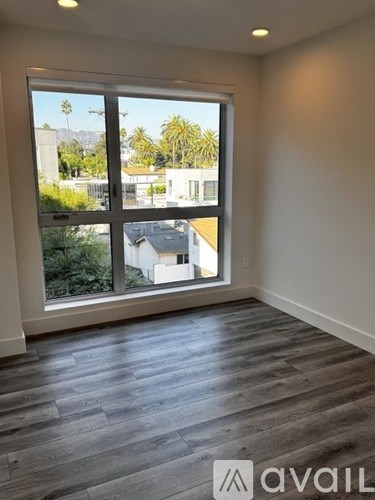 A room with a large window overlooking a residential area.