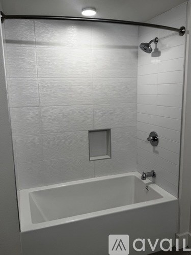 A white bathroom with a tub and a shower.