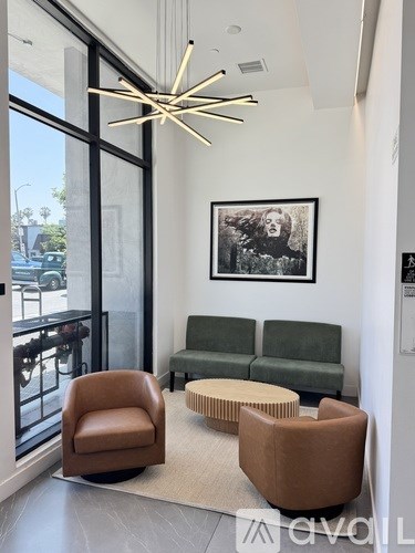 A living room with a brown chair, a green couch, and a framed picture on the wall.