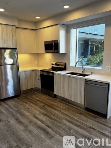 A kitchen with wooden cabinets and a stainless steel refrigerator.
