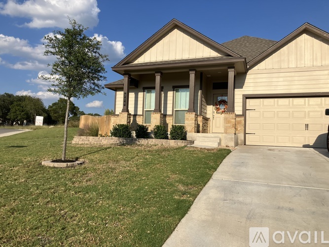 A house with a garage and a tree in front.