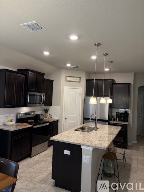 A kitchen with black cabinets and granite countertops.