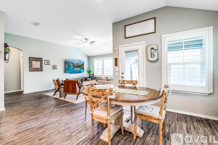 A dining room with a wooden table and chairs.