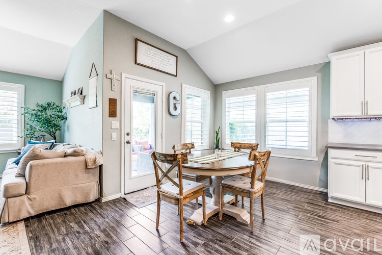 A dining room with a wooden table and chairs.