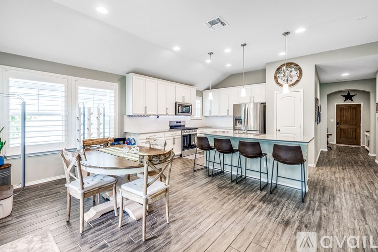 A modern kitchen with a dining table and chairs.