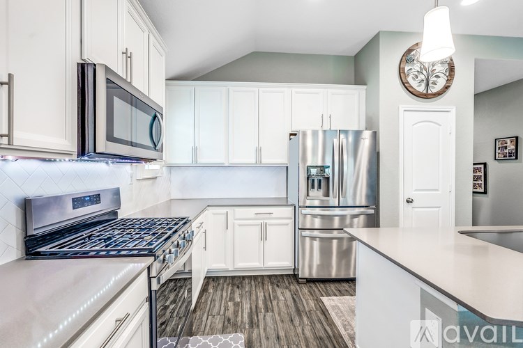 A kitchen with white cabinets and stainless steel appliances.