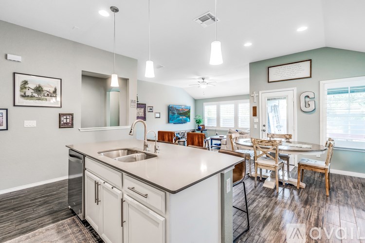 A kitchen with a white countertop and wooden flooring.