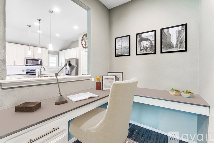A modern kitchen with a desk and chair in the foreground.