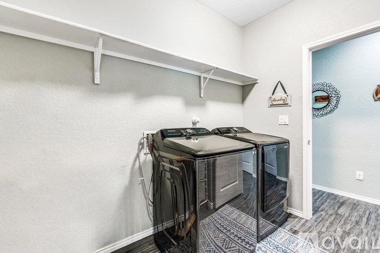 A kitchen with a white wall and a fridge and microwave on top of a counter.