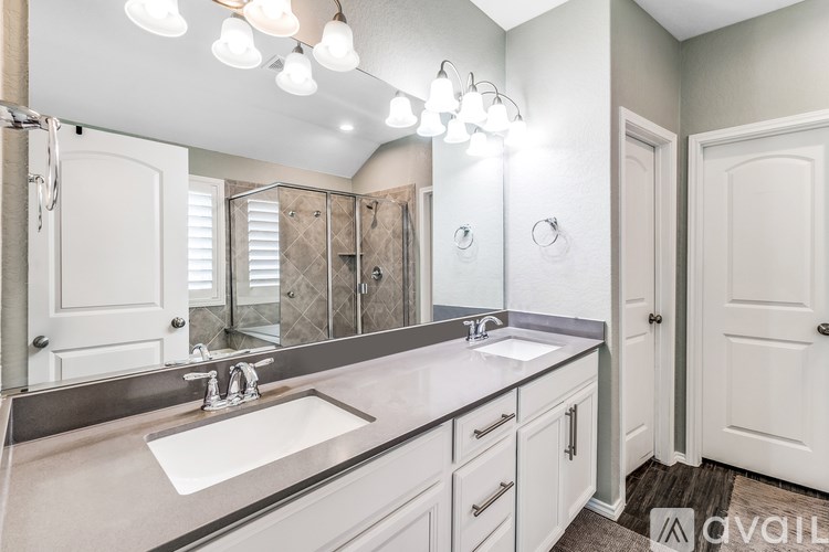 A bathroom with a sink, mirror, and lighting fixture.