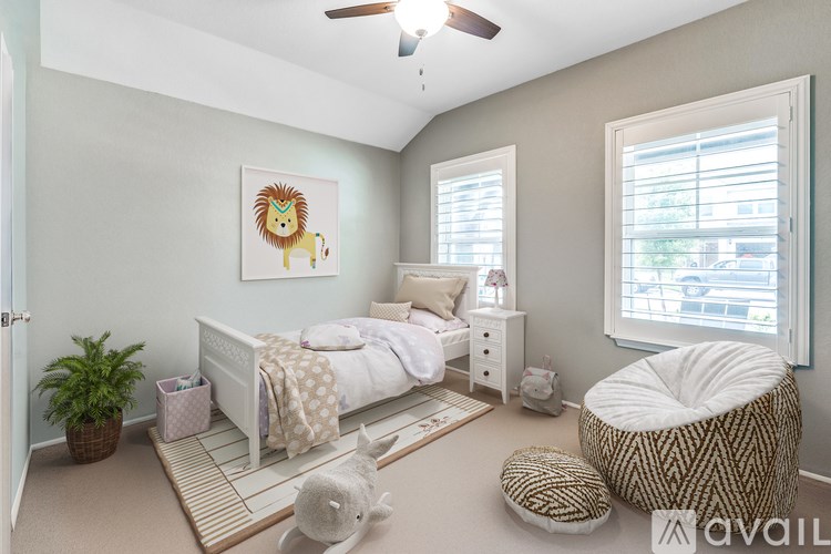 A bedroom with a bed, a chair, and a painting of a lion on the wall.