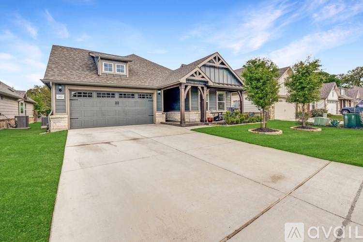 A house with a garage and a driveway in front of it.