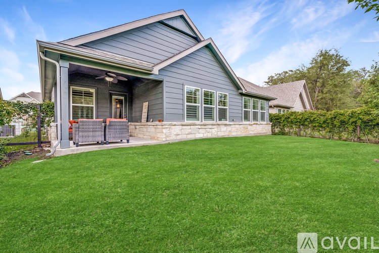 A house with a blue exterior and a large lawn in front.