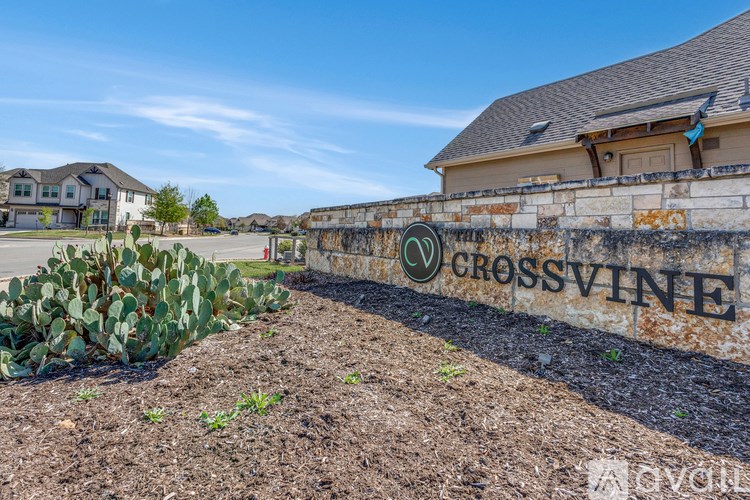 A wall with the word "CROSSVINE" on it is in front of a building.